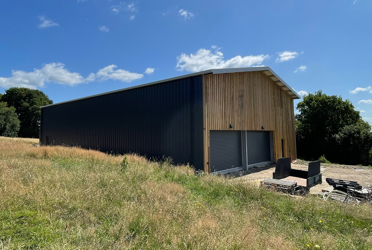 Wood clad steel-frame winery building with roller shutter doors.
